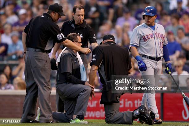 Home plate umpire Kerwin Danley is attended to after being struck with a ball in the fourth inning of the New York Mets verses the Colorado Rockies...