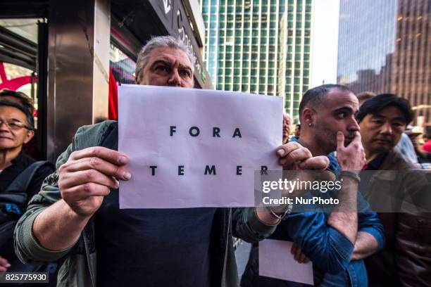 Demonstrators protest at Paulista Avenue in Sao Paulo, Brazil, as they watch a screen showing lawmakers voting in Brasilia on whether to put...