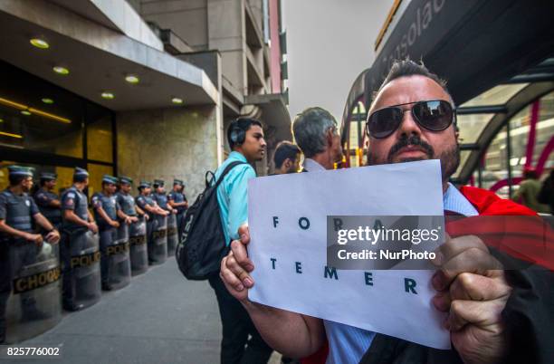 Demonstrators protest at Paulista Avenue in Sao Paulo, Brazil, as they watch a screen showing lawmakers voting in Brasilia on whether to put...