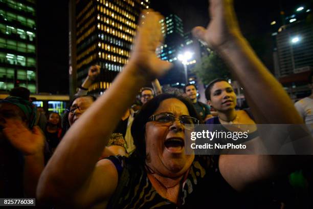 Demonstrators protest at Paulista Avenue in Sao Paulo, Brazil, as they watch a screen showing lawmakers voting in Brasilia on whether to put...