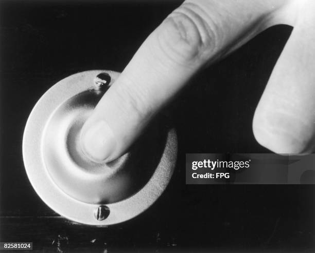 Finger pressing a doorbell, circa 1950.