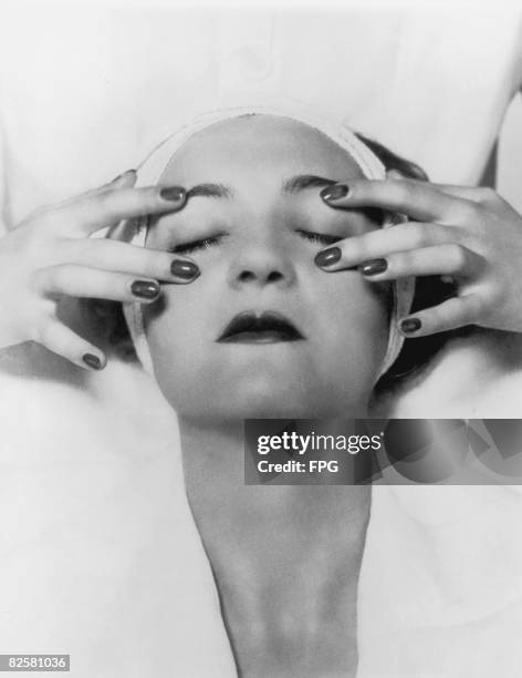 Woman closes her eyes to enjoy a facial massage, circa 1935.