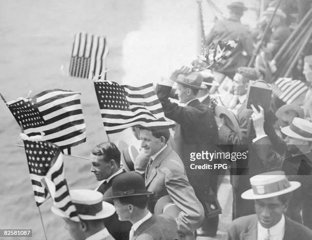 American athletes wave flags and take photographs as they set sail for the 1920 Olympics in Antwerp.