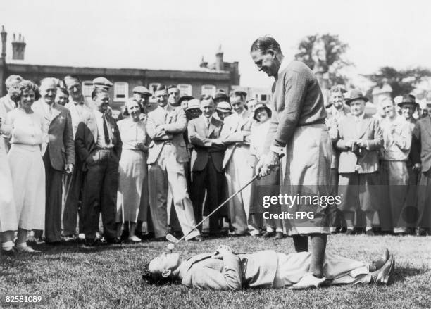 Australian golfer Joe Kirkwood tees off from a caddy's mouth, circa 1930.