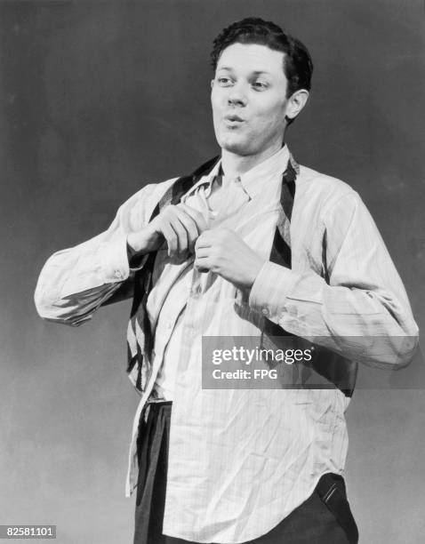 Man whistles as he dons his shirt and tie, circa 1950.