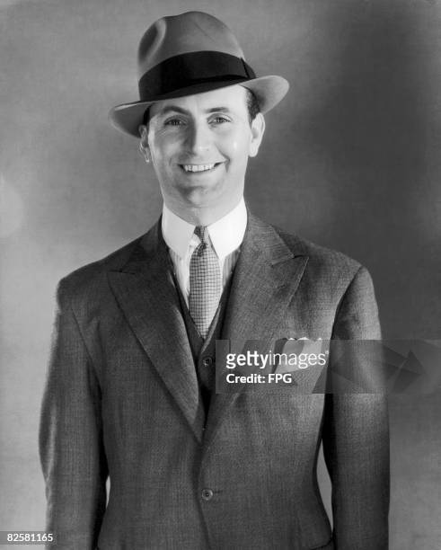 Circa 1950, A smiling man in a trilby and suit.
