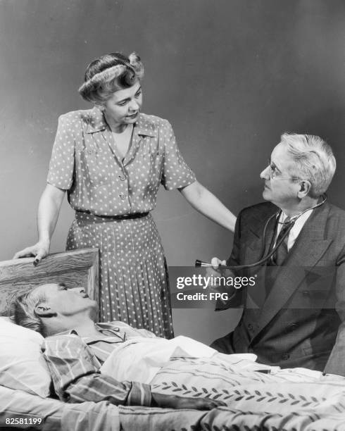 Circa 1945, A doctor discusses a patient's health with the man's wife.