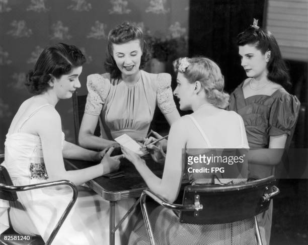Circa 1950, Four young ladies gather round a card table for an evening of fun.