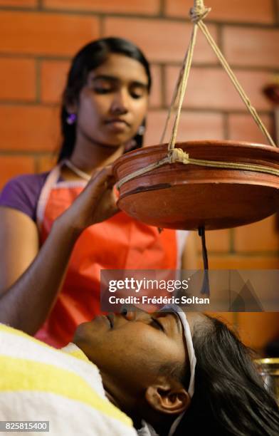 Ayurvedic retreat in Kerala. Ayurvedic treatment, characterized by dripping oil on the forehead, on a patient following a cure at the Ayurveda Mana...