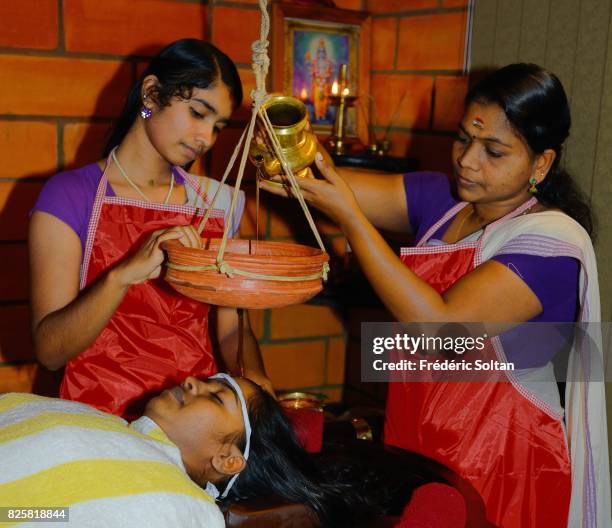 Ayurvedic retreat in Kerala. Ayurvedic treatment, characterized by dripping oil on the forehead, on a patient following a cure at the Ayurveda Mana...