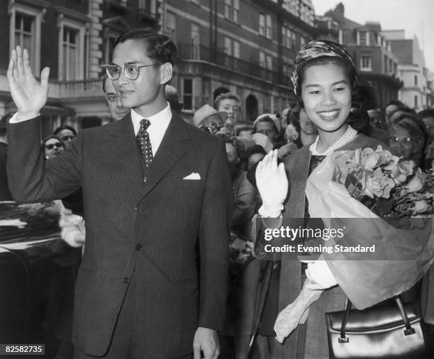 King Bhumibol and Queen Sirikit of Thailand wave to the crowds during a visit to Britain, 1960.