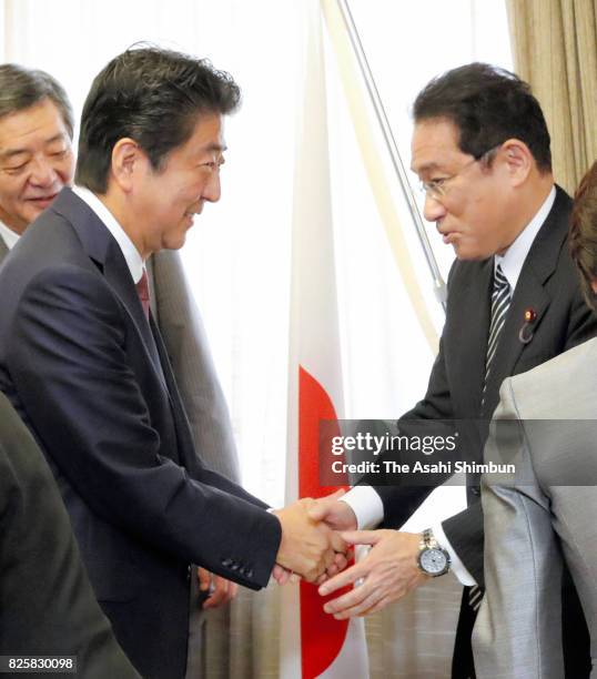 Prime Minister and ruling Liberal Democratic Party President Shinzo Abe and new chairman of the Policy Research Council Fumio Kishida shake hands at...