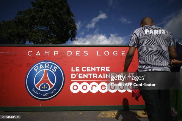 Fan stands in front of the entrance of the Paris Saint-Germain's Camp des Loges training centre in Saint-Germain-en-Laye, western Paris on August 3...