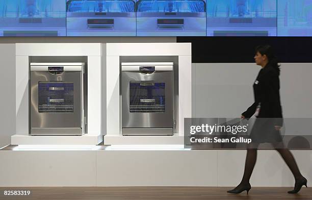 Woman walks past energy-efficient ovens at the Bosch stand ahead of the opening evening at the IFA consumer elctronics trade fair on August 28, 2008...