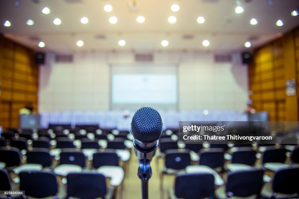 Microphone over the Abstract blurred photo of conference hall or seminar room background