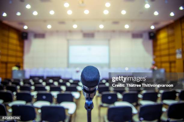 microphone over the abstract blurred photo of conference hall or seminar room background - presentation speech stock pictures, royalty-free photos & images