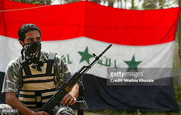 Member of the U.S.-backed Neighborhood Patrol Awakening Council stands guard in front of an Iraqi flag on August 28, 2008 in the Sunni Adhamiya...