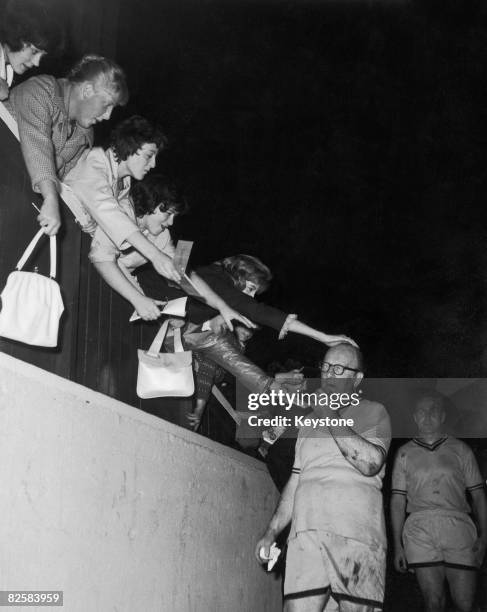 British band leader Billy Cotton gets a pat on his head as he comes off the field after the Show Biz versus Football Writers XI Charity Football...