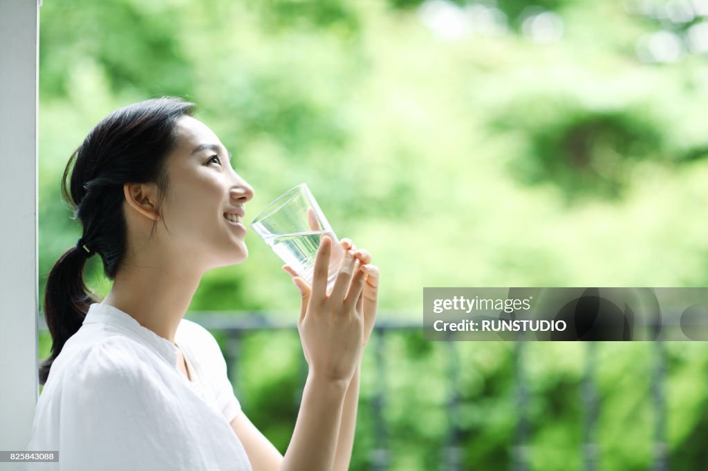 Young happy woman with glass of water