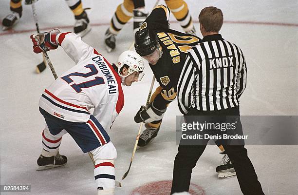 Canadiens center Guy Carbonneau and Bruins counterpart Thomas Gradin wait for linesman Swede Knox to drop the puck at the Montreal Forum during the...