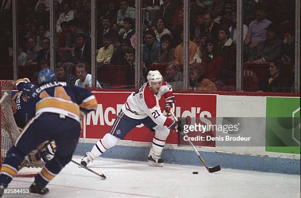 Canadiens forward Guy Carbonneau carries the puck against St. Louis opponents at the Montreal Forum during the 1987-88 season.