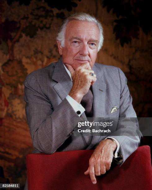 Portrait of American broadcast journalist Walter Cronkite as he stands behind a chair and rests his chin in his hands, New York, New York, 1983.