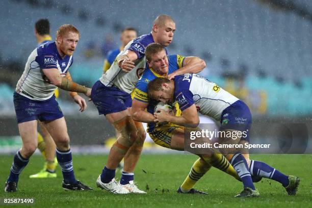 Daniel Alvaro of the Eels is tackled during the round 22 NRL match between the Canterbury Bulldogs and the Parramatta Eels at ANZ Stadium on August...