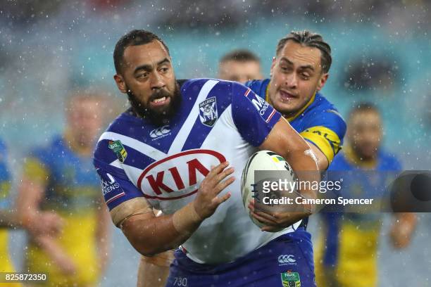Sam Kasiano of the Bulldogs is tackled during the round 22 NRL match between the Canterbury Bulldogs and the Parramatta Eels at ANZ Stadium on August...