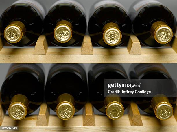 wine bottles in rack - wine rack stock pictures, royalty-free photos & images