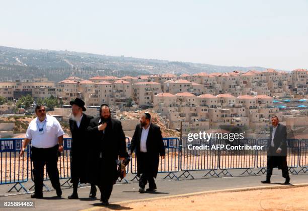 Ultra-orthodox Jews walk at the site of a corner stone ceremony for a new neighbourhood in the Beitar Illit settlement, which is the largest in the...