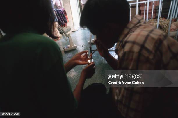Thai youths inhale the fumes from amphetamine powder which is heated from underneath on a piece of foil. Amphetamines or 'ya ba' abuse has become a...