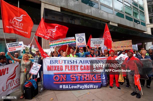 Demonstrators hold placards as they protest over against a British Airways mixed fleet cabin crew pay-dispute, outside the Civil Aviation Authority ,...