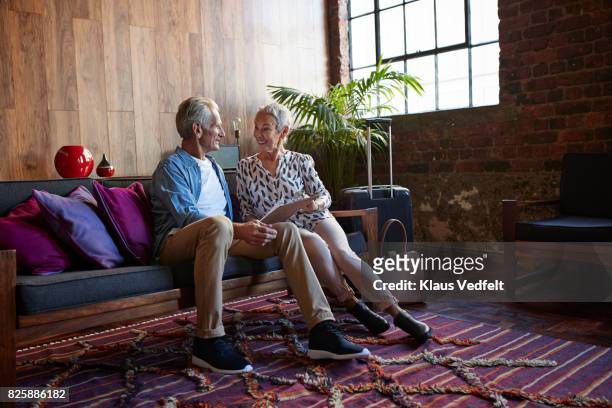mature couple looking threw tjeck-in clip board, after arrival in rental flat - luxury break ストックフォトと画像