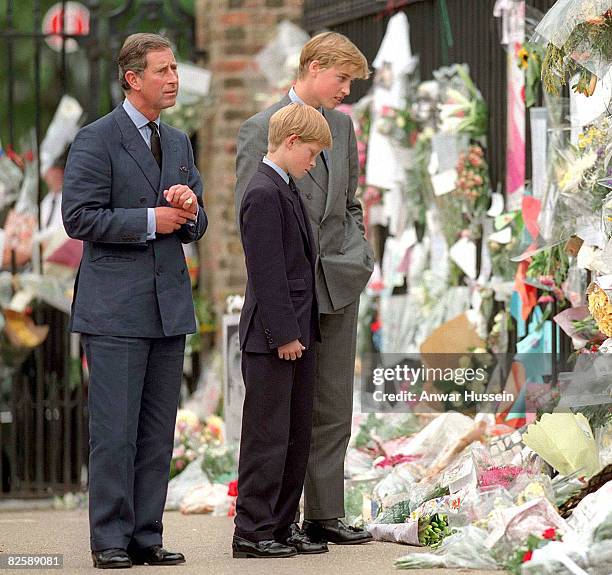 The Prince of Wales with his sons Prince William and Prince Harry look sadly at floral tributes for Diana, The Princess of Wales outside Kensington...