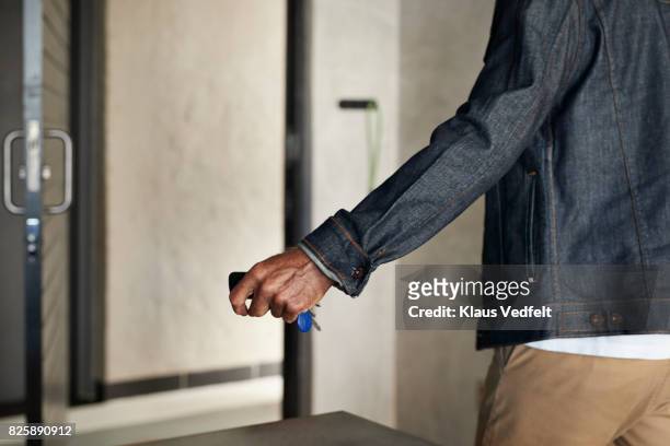 senior man grabbing keys, when leaving apartment - afferrare foto e immagini stock