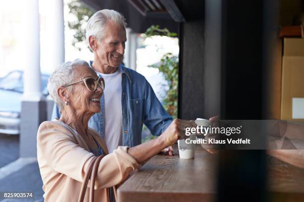 senior couple ordering coffee to-go, at street bakery - consumer journey stock pictures, royalty-free photos & images