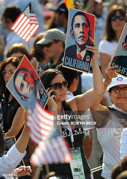 An Obama supporter from California hoists a poster of Democratic nominee Barack Obama during the Democratic National Convention 2008 at the Invesco...