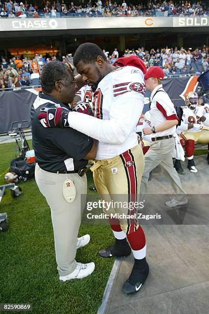 Chaplain Earl Smith prays with Walter Curry of the San Francisco 49ers during the NFL game against the Chicago Bears at Soldier Field on August 21,...