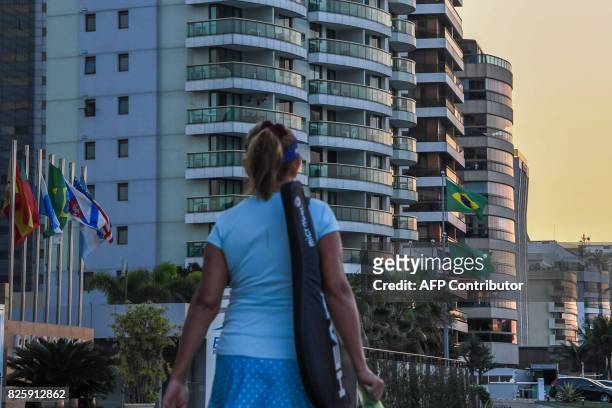 Woman walks in front of hotels at Praia da Barra in Rio de Janeiro on August 3, 2017. Rio de Janeiro almost duplicated its hotel capacity in 2016 for...
