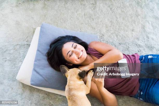 señora joven latina jugando con perrito - petite latina fotografías e imágenes de stock