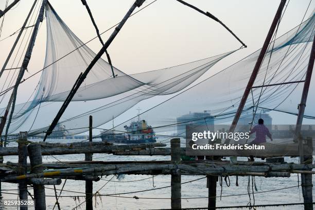 Cochin Lagoon in Kerala. Chinese fishing nets and the oil and gas company Wipro, in background, in the port city of Kochi, in the state of Kerala on...