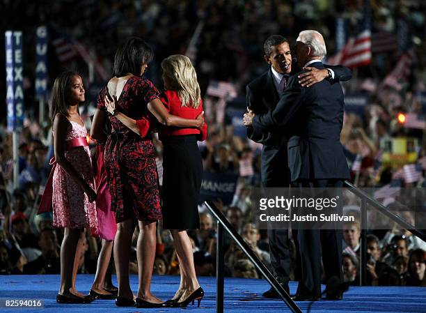 Democratic U.S. Presidential nominee Sen. Barack Obama speaks with running mate U.S. Sen. Joe Biden , while Michelle Obama and Jill Biden hug, and...