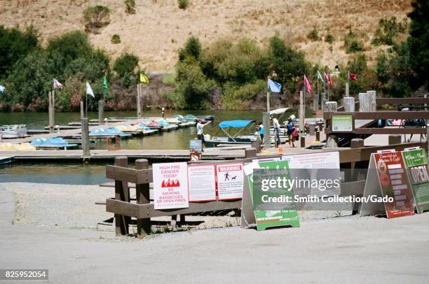 Signage, including a fire warning sign, at the Chabot Marina on Lake Chabot, an East Bay Regional Park in the San Francisco Bay Area town of Castro...