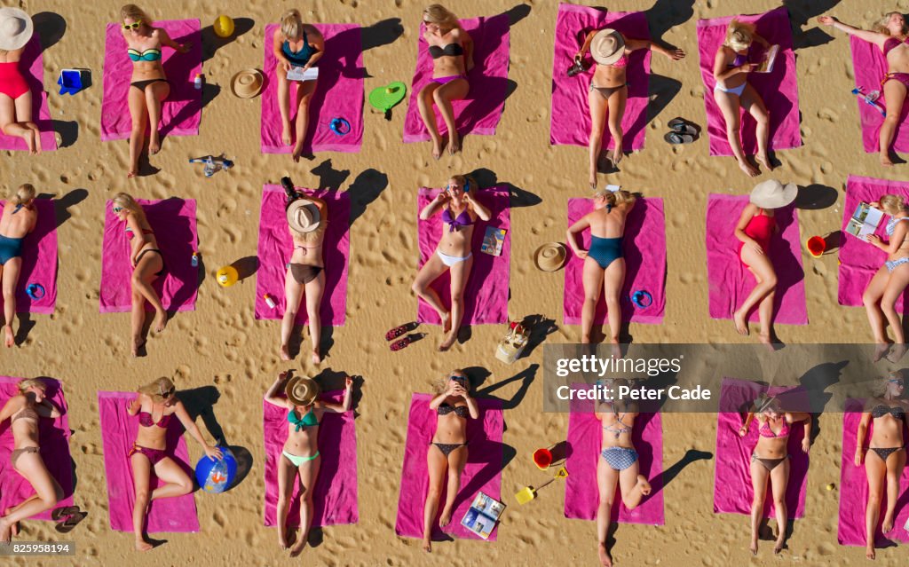 Aerial shot of duplicated woman sunbathing on beach