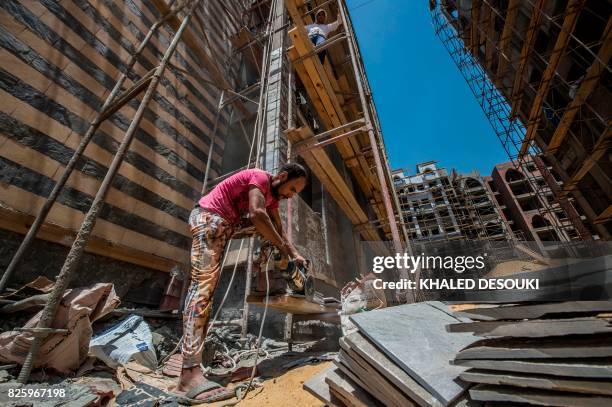 Labourers work at the construction site of the new Egyptian administrative capital, some 40 kms east of Cairo, on August 3, 2017. Egypt plans to...