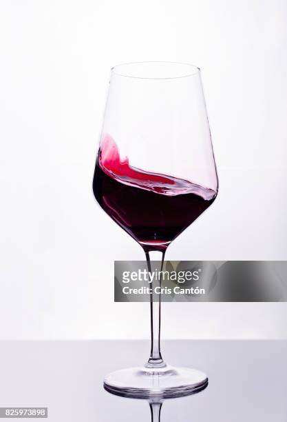 red wine swirling into glass - red wine foto e immagini stock
