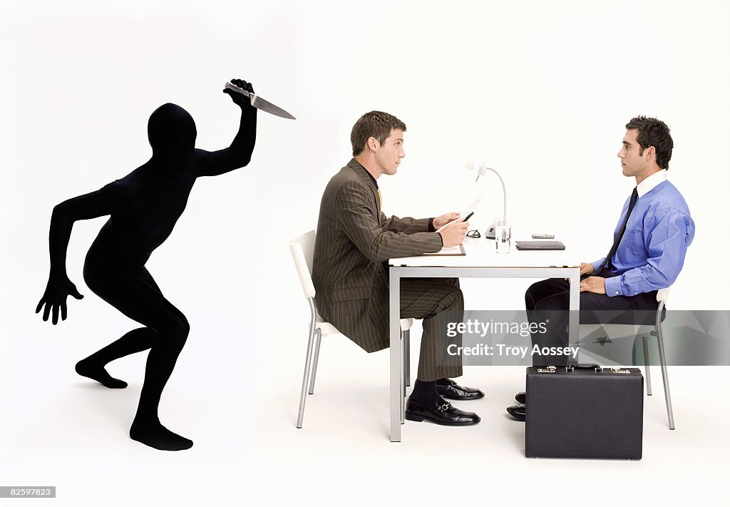 Business men in meeting with backstabber.