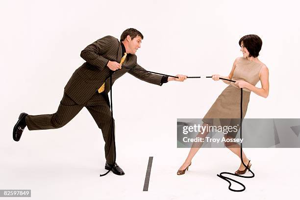 man and woman playing tug of war - 綱引き ストックフォトと画像