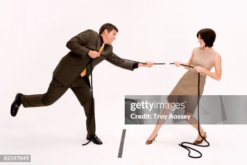 Man and woman playing tug of war Man and woman playing tug of war