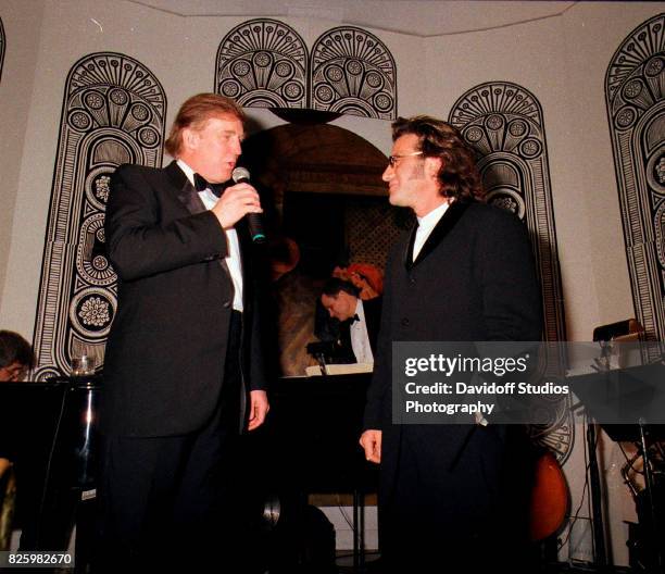 American real estate developer Donald Trump stands with musician Tico Torres on stage during a 'roaring 20's' party at the Mar-a-Lago estate, Palm...